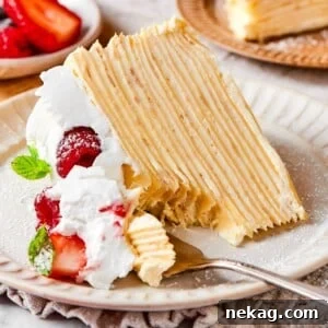 A lifted bite of crepe cake featuring soft creamy layers and a smooth vanilla texture.
