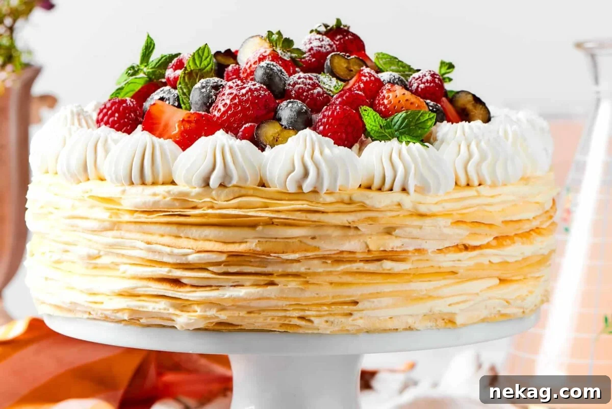 Delicate Layered Crepe Dessert 5 A full crepe cake decorated with fruit and creamy topping ready for the table.