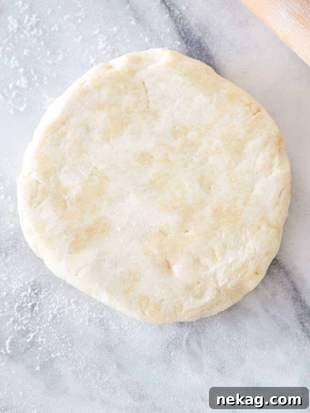 Flaky Butter Crust Perfection 5 Unrolled pie dough disk on a floured marble surface, ready for transfer.