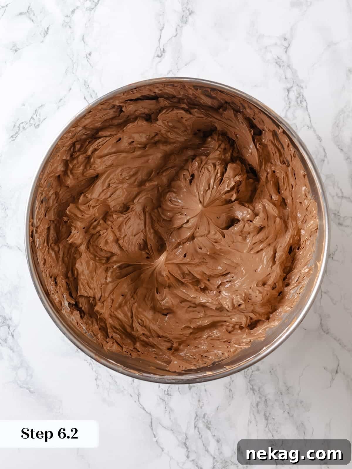 Fully mixed chocolate Swiss meringue buttercream sitting in a bowl, looking glossy and perfectly smooth, ready for use.
