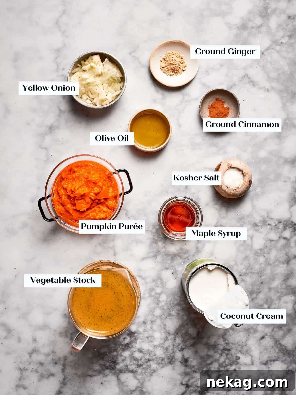 Wholesome Vegan Pumpkin Harvest Soup 4 Pumpkin soup ingredients neatly arranged on a countertop, including canned pumpkin puree, a can of coconut cream, diced yellow onions, and various spices.