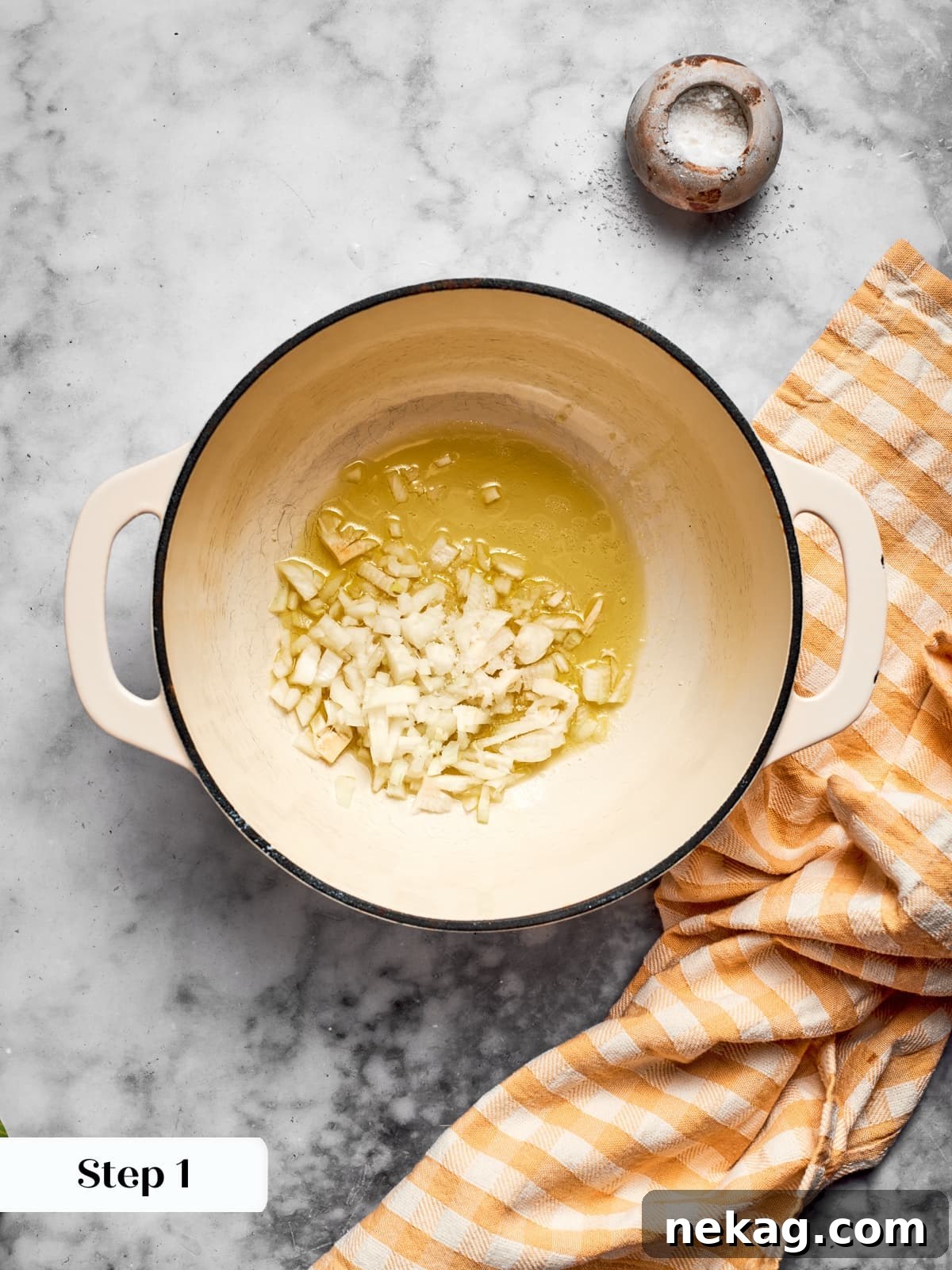 Wholesome Vegan Pumpkin Harvest Soup 6 Diced yellow onions sautéing in a warm pan with olive oil, creating an aromatic base for the soup.