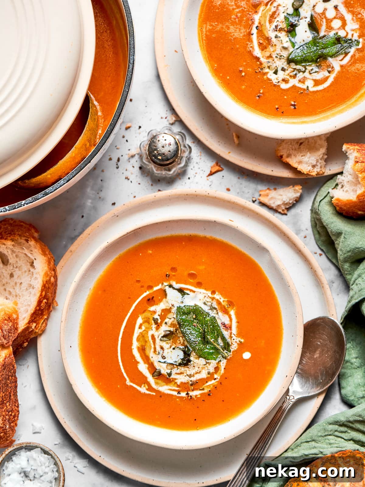 Wholesome Vegan Pumpkin Harvest Soup 9 A vibrant, bright orange vegan pumpkin soup, garnished with a swirl of coconut cream and a delicate drizzle of olive oil, ready to be served.