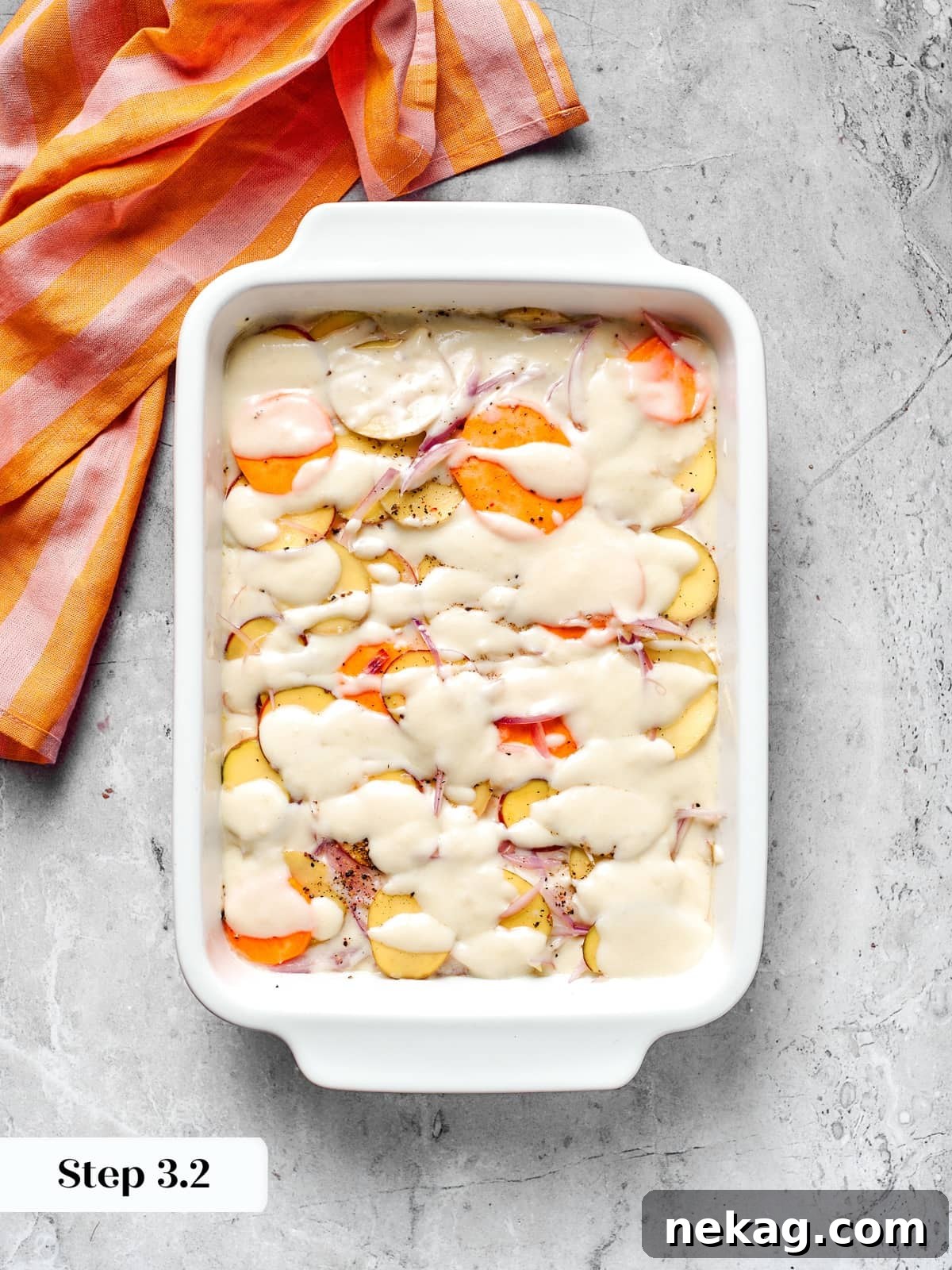 Cheese sauce drizzled over layered potatoes during scalloped potatoes assembly.