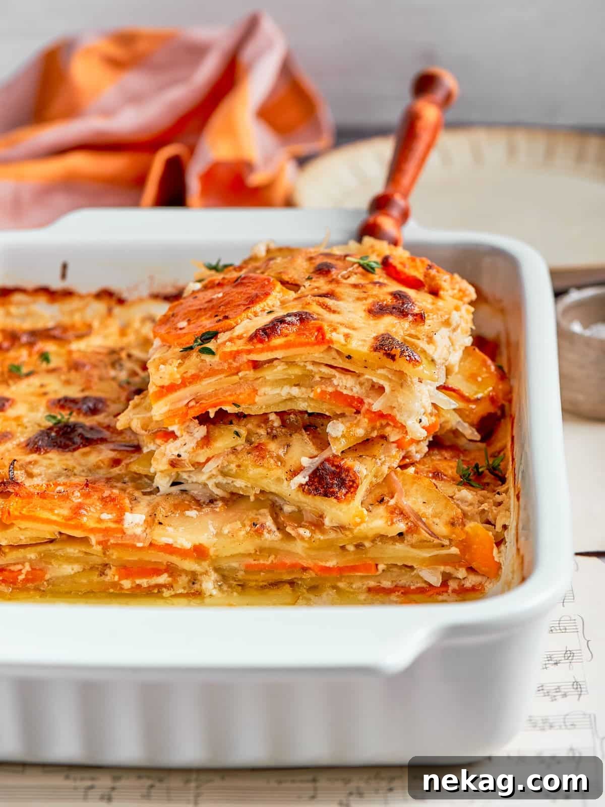 Layered scalloped potatoes lifted from the dish showing creamy sauce and tender slices.