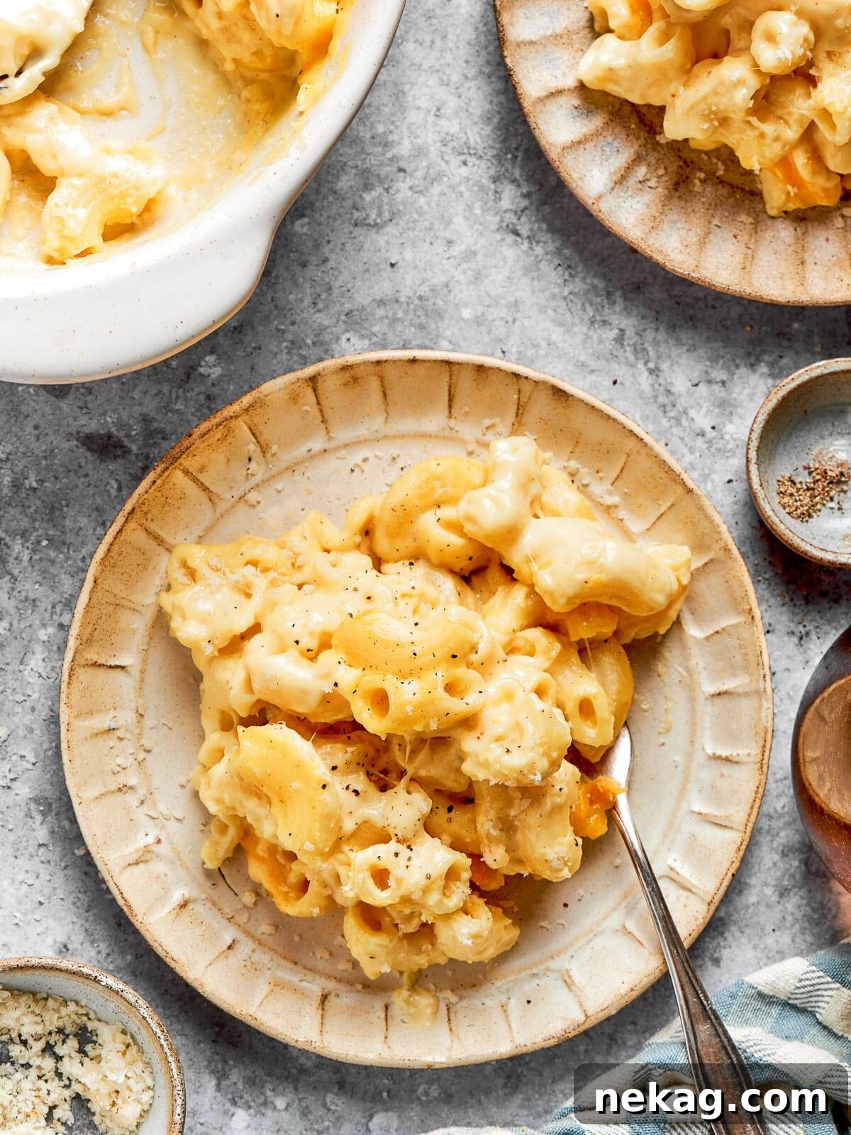 Ultimate Baked Mac and Cheese 18 A generously portioned plate of golden, cheesy mac and cheese, perfectly baked and ready to be devoured, sitting on a kitchen countertop.