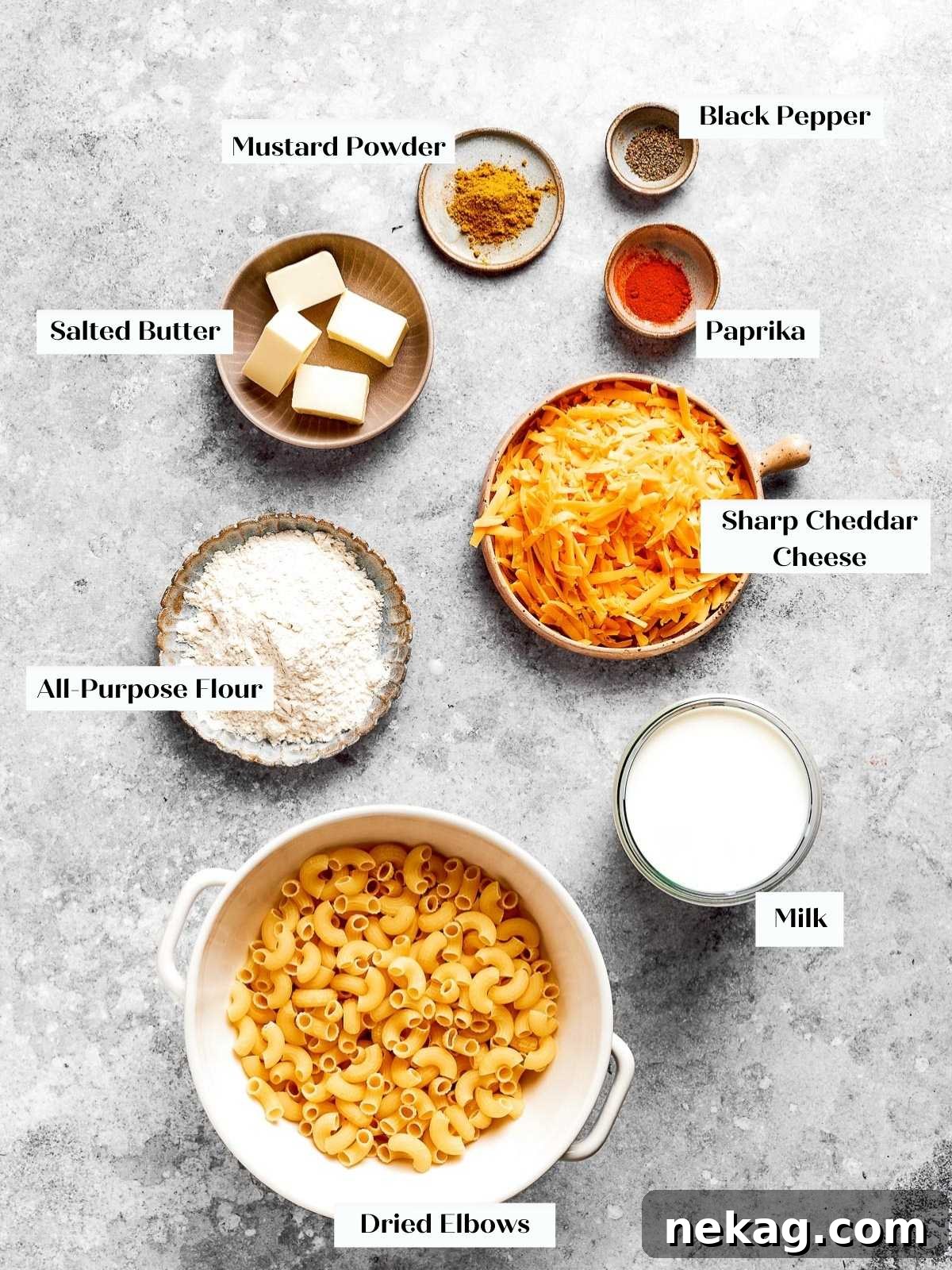 Ultimate Baked Mac and Cheese 4 An array of fresh, high-quality ingredients laid out on a kitchen countertop, including dried elbow macaroni, blocks of sharp cheddar, butter, milk, flour, and various spices, all ready for making baked mac and cheese.