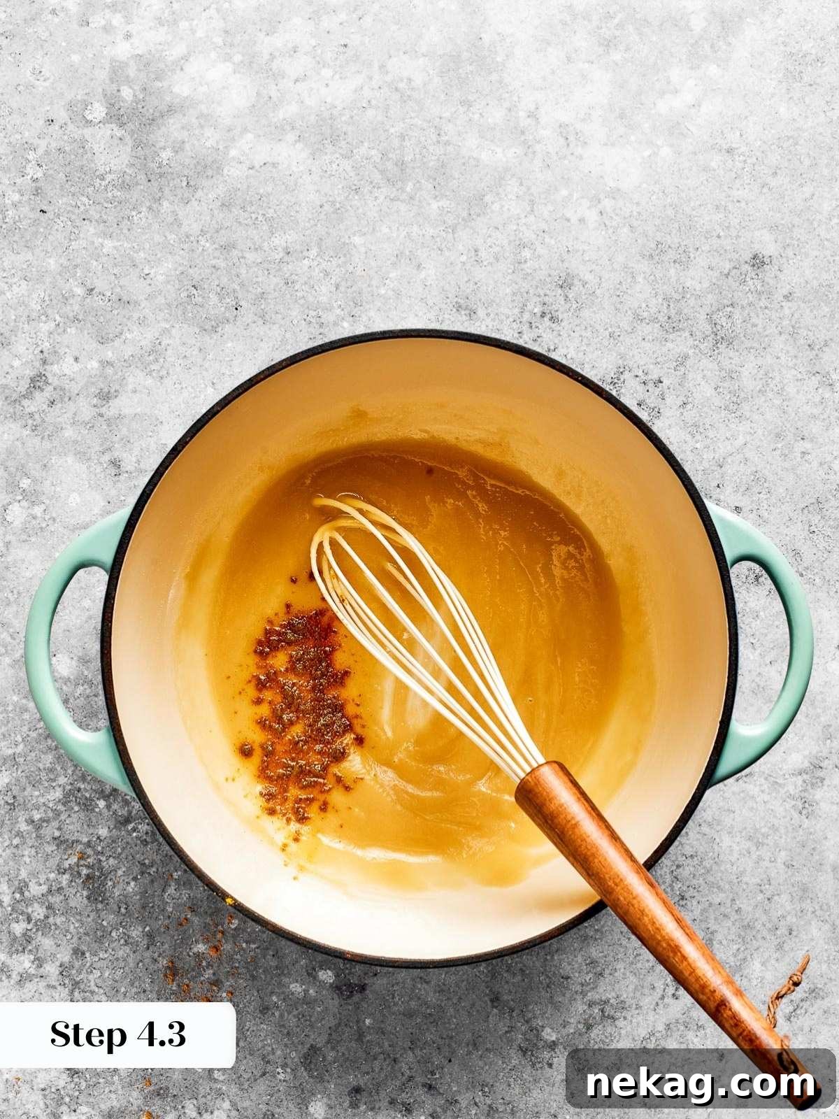 Ultimate Baked Mac and Cheese 8 A whisk stirring a smooth, pale roux in a saucepan over low heat, ensuring no lumps before adding liquids.