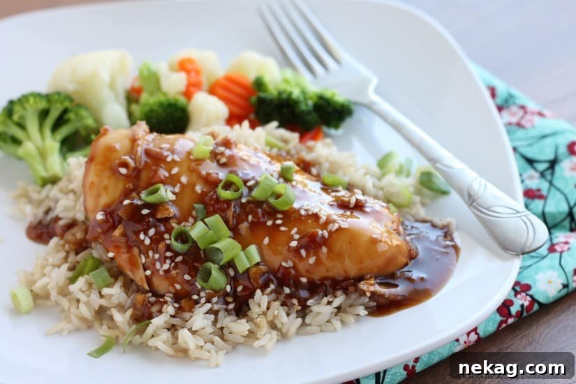 Close-up of tender Crockpot Asian Sesame Chicken with its thick, caramelized sauce