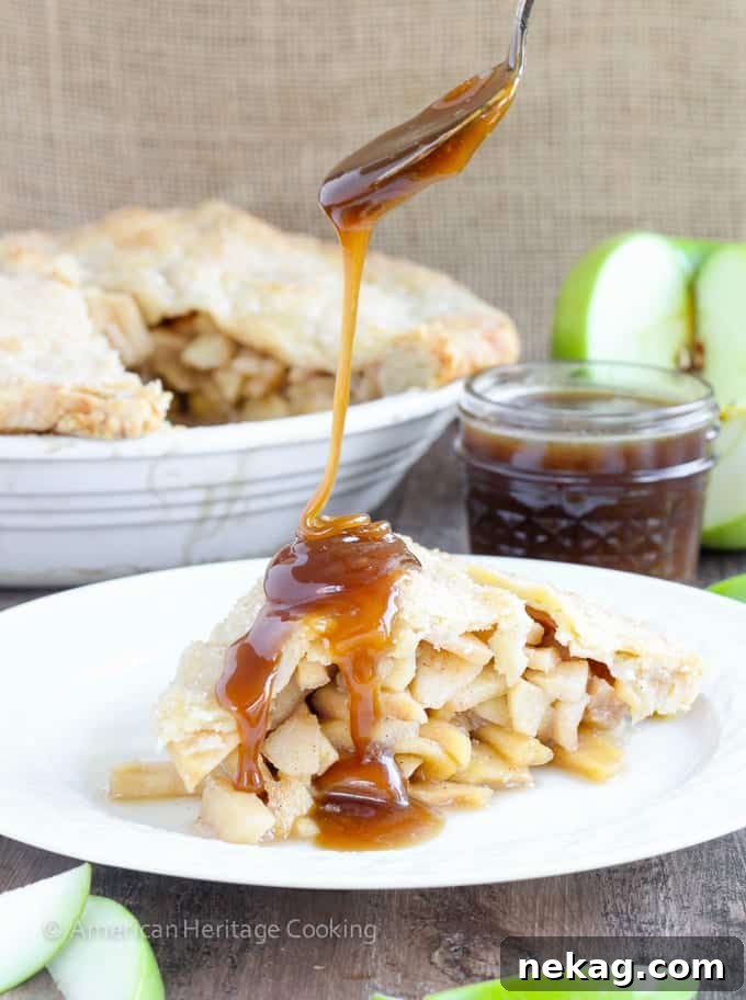 A freshly baked slice of Apple Butterscotch Pie, revealing layers of fruit and sauce, perfect for a serving.