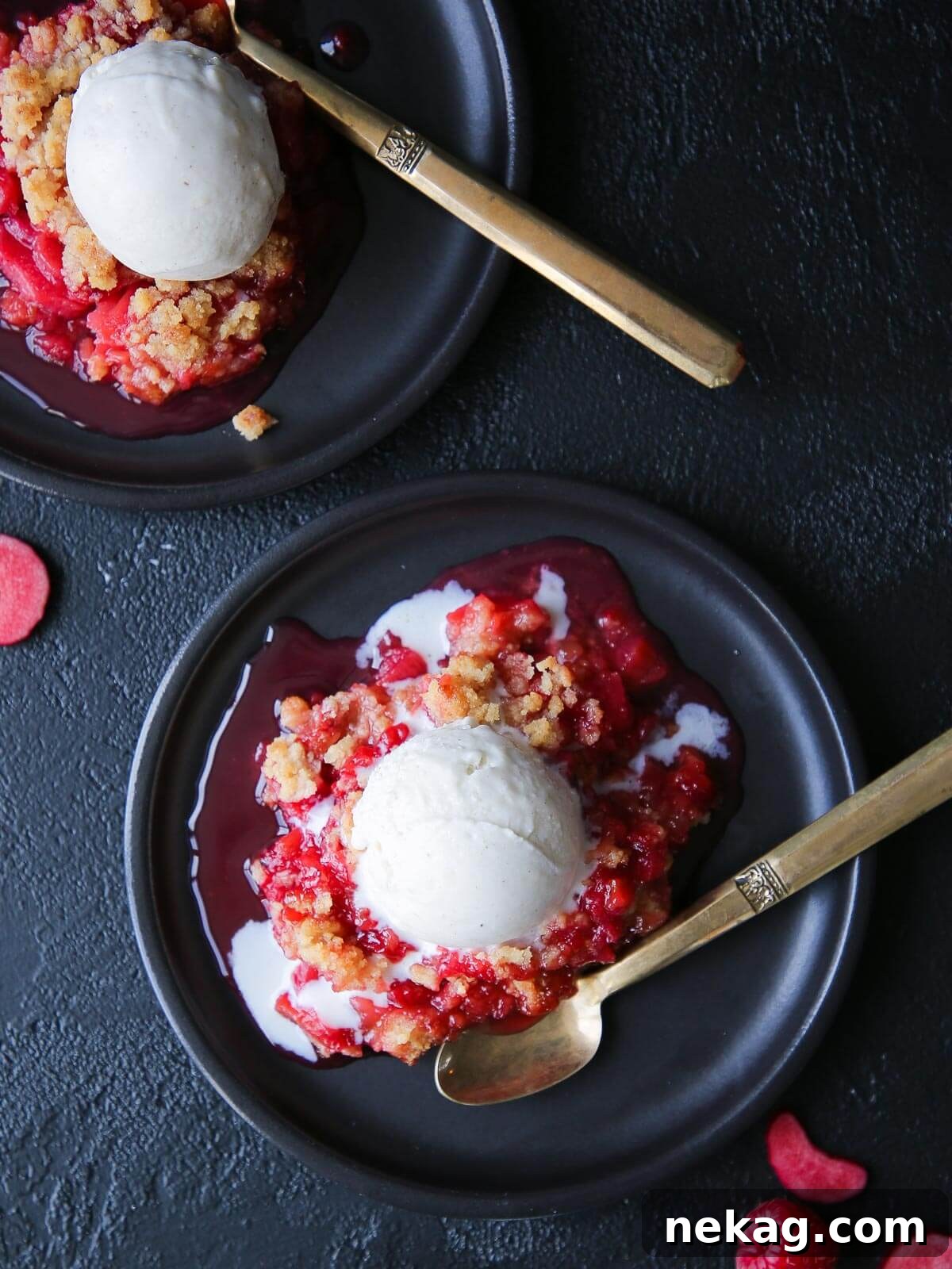Tangy Raspberry Rhubarb Delight 2 Fresh raspberries scattered near a served portion of crisp, highlighting its vibrant ingredients and inviting presentation.