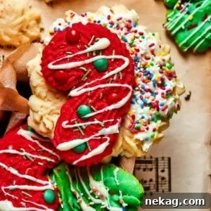A festive candy cane-shaped spritz cookie, beautifully decorated with tiny colorful candy dots, making it a perfect holiday treat.