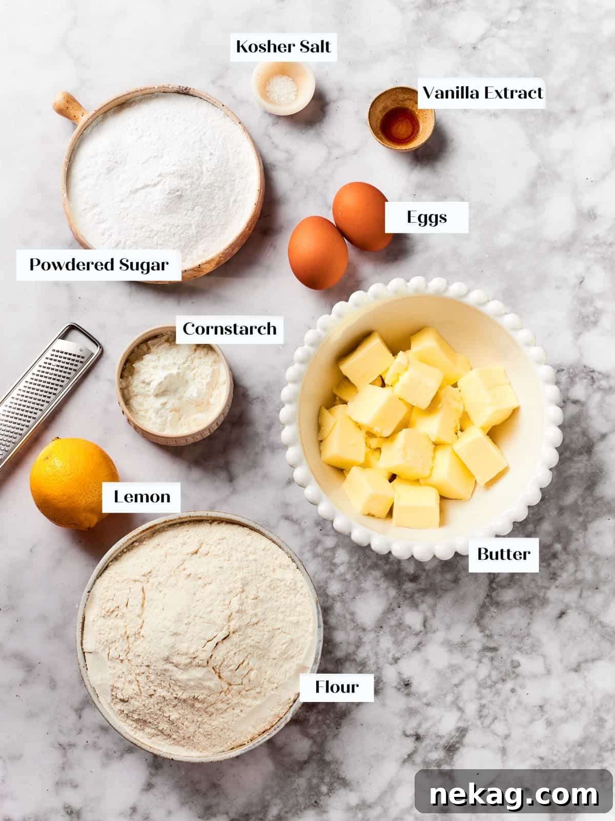 Carefully arranged ingredients for spritz cookies, including soft butter, fresh eggs, all-purpose flour, and powdered sugar, on a clean kitchen countertop.