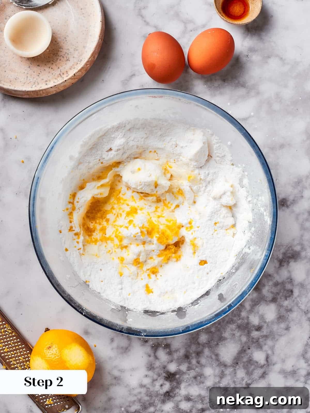 Butter, powdered sugar, salt, and lemon zest combined in a mixing bowl, ready to be creamed for the spritz cookie dough.