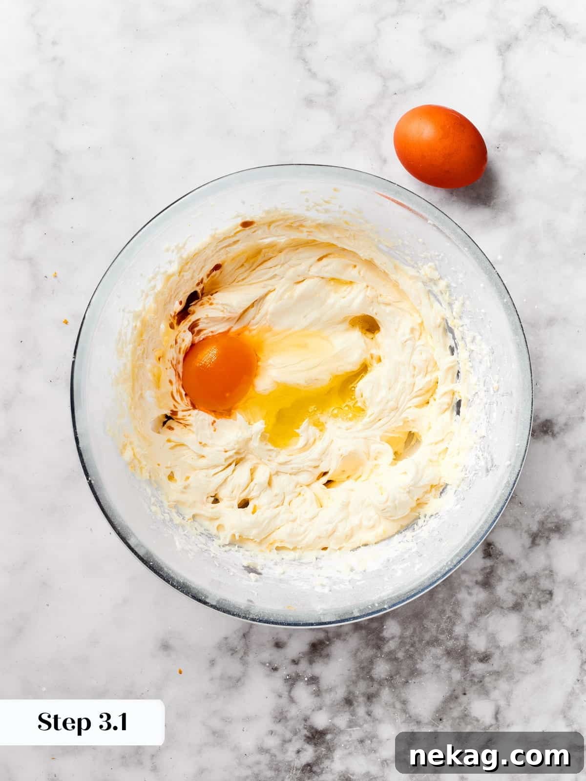 In a mixing bowl, eggs and vanilla extract are being whisked together, creating a smooth mixture for the rich spritz cookie dough.