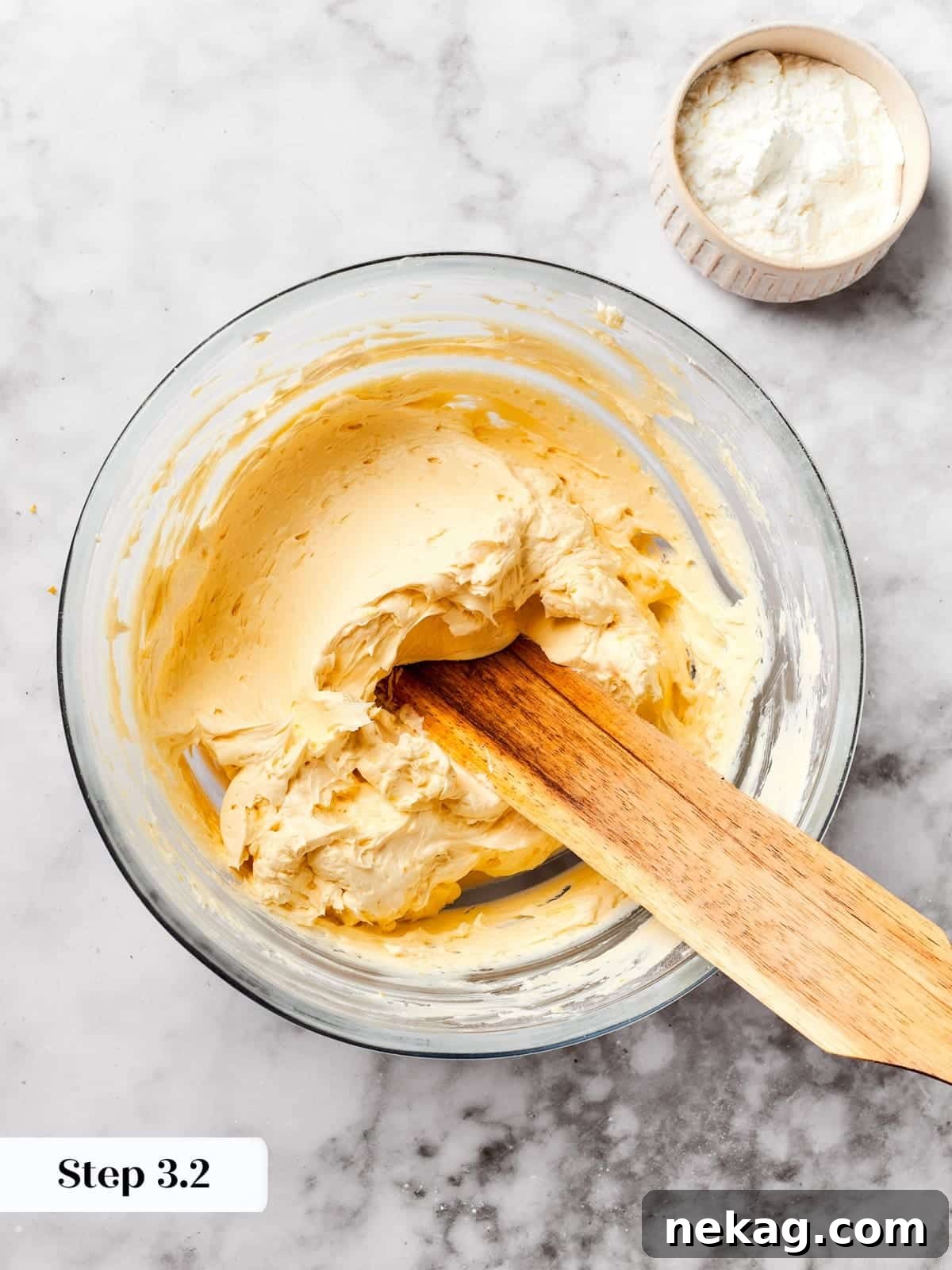 Softened butter being added to a stand mixer bowl, the initial step in preparing the delicate spritz cookie base.