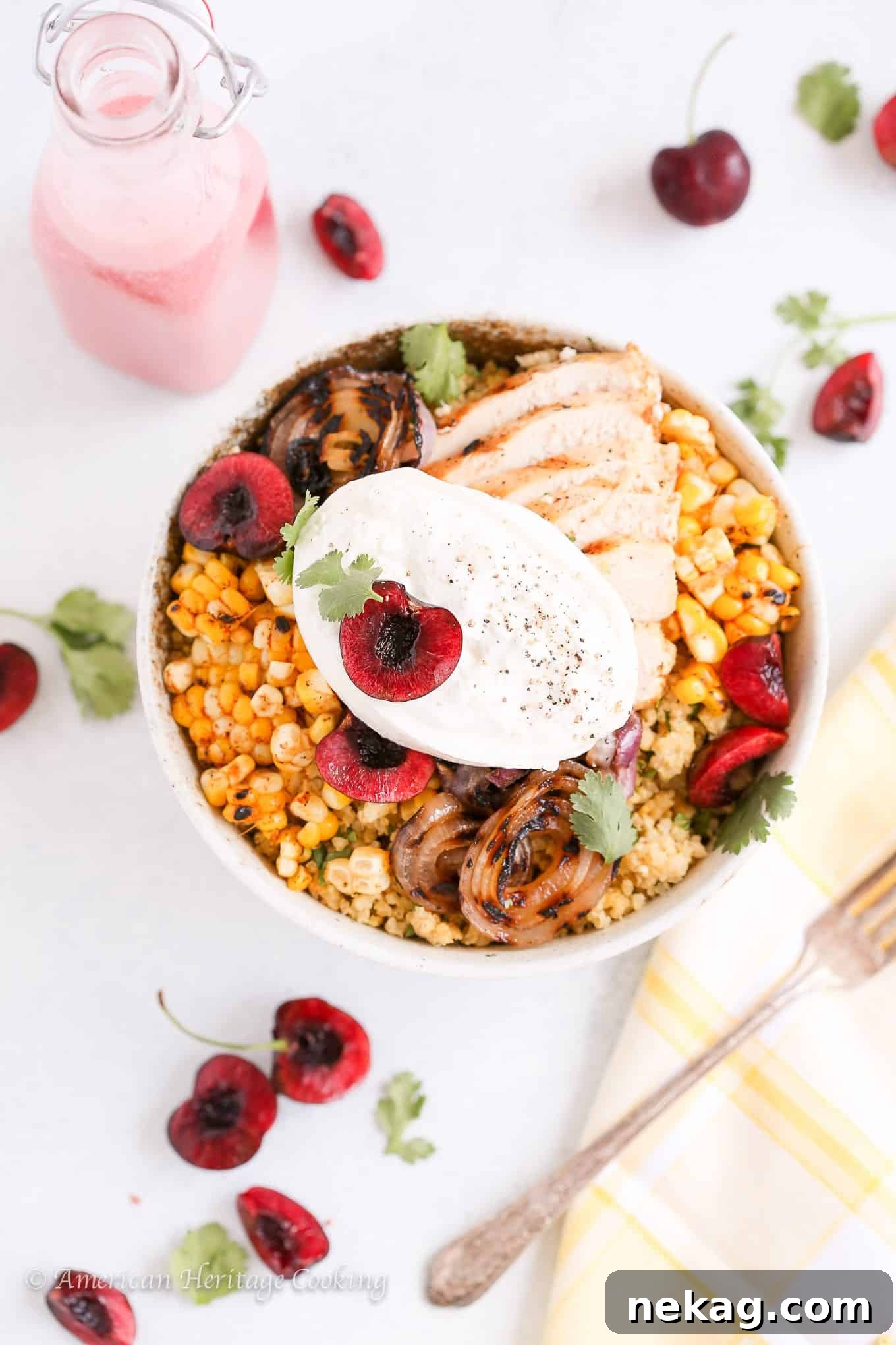 A beautifully plated Cherry Burrata Millet Grain Bowl with grilled chicken, fresh cherries, and creamy burrata on top.