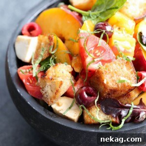 Stone Fruit Capreses Panzanella Salad in a black wooden bowl, ready to serve.