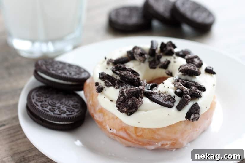 An overhead shot showcasing two Cookies and Cream Donuts, highlighting the perfectly piped cream cheese frosting and generously sprinkled crushed Oreos.