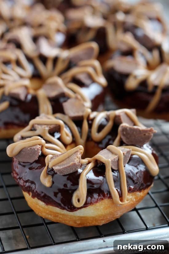 A stack of Chocolate Peanut Butter Cup Donuts, highlighting the dark ganache and peanut butter.