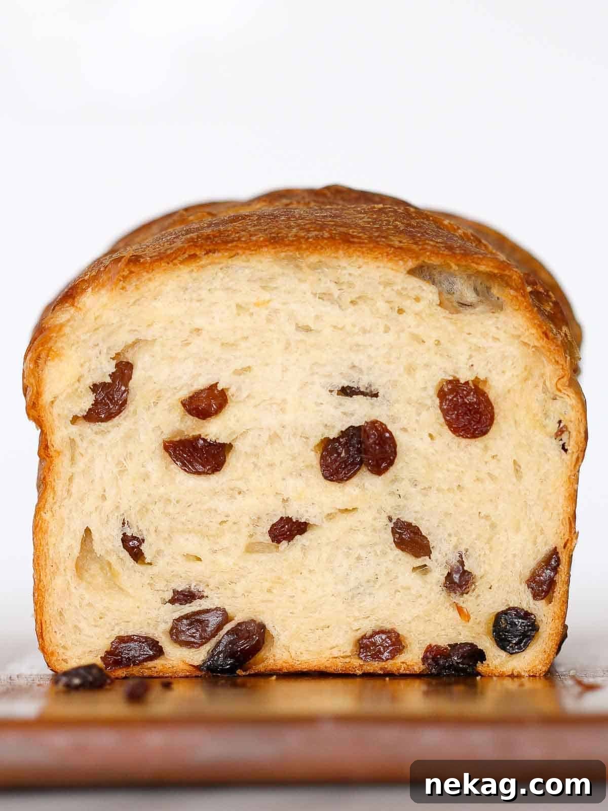 Sweet and Tangy Raisin Sourdough 2 A perfectly sliced sourdough raisin bread loaf showcasing its soft crumb and abundant raisins, set against a pristine white background.