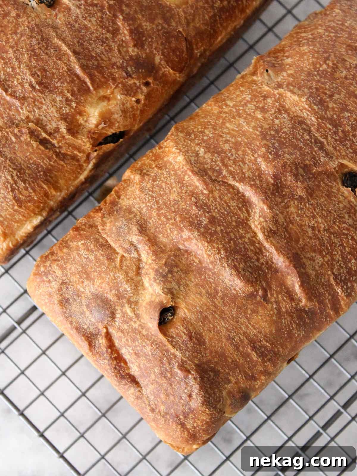 Sweet and Tangy Raisin Sourdough 8 Two freshly baked sourdough raisin loaves cooling on a wire rack, their golden crusts promising deliciousness.