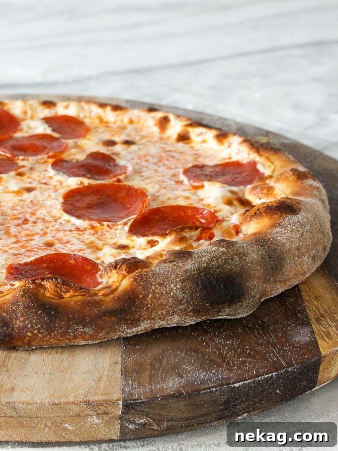 Ultimate Sourdough Pizza Dough Recipe 5 Finished sourdough pizza served on a rustic wooden board, ready to be sliced.