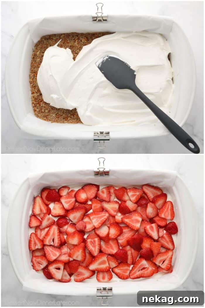 Spreading cream cheese filling over pretzel crust and topping cream with fresh strawberries.