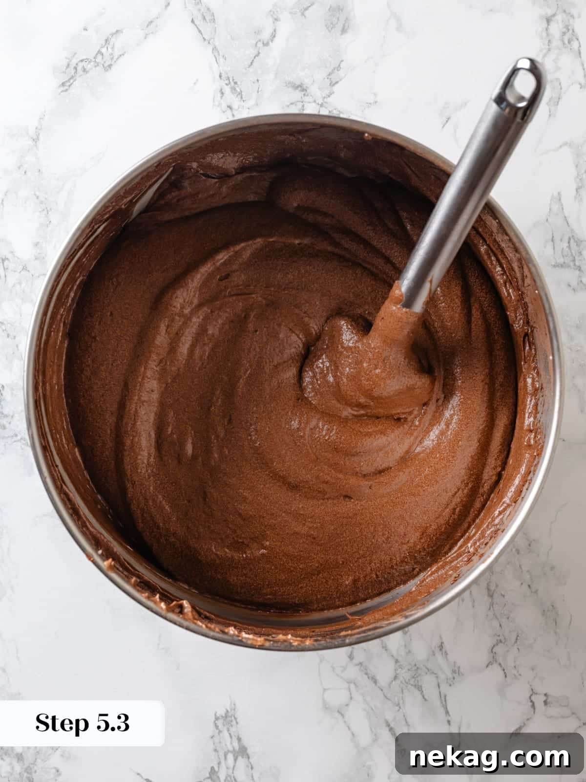 Sinfully Rich Chocolate Cake 12 A spatula is used for the final gentle folding of the batter, ensuring all dry ingredients are just combined without overmixing.