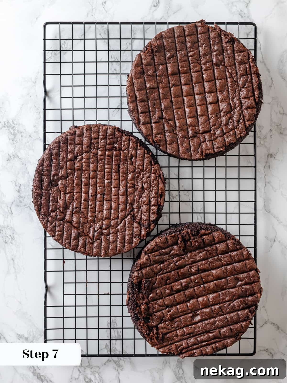 Sinfully Rich Chocolate Cake 14 Warm chocolate cake layers are carefully placed on a wire rack, allowing proper airflow for cooling and steam release before frosting.