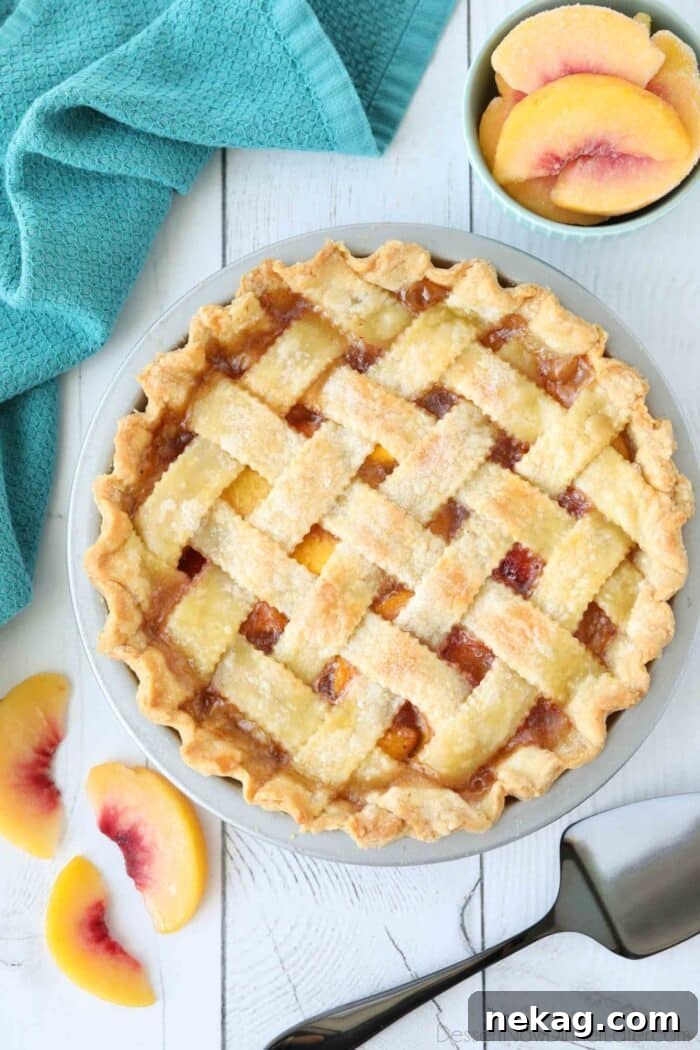 An overhead shot of a peach pie with a beautifully woven lattice crust, showing the golden-brown pastry.
