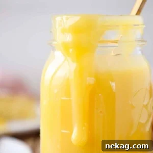 Lemon curd dripping down the side of a mason jar, illustrating its luscious texture.