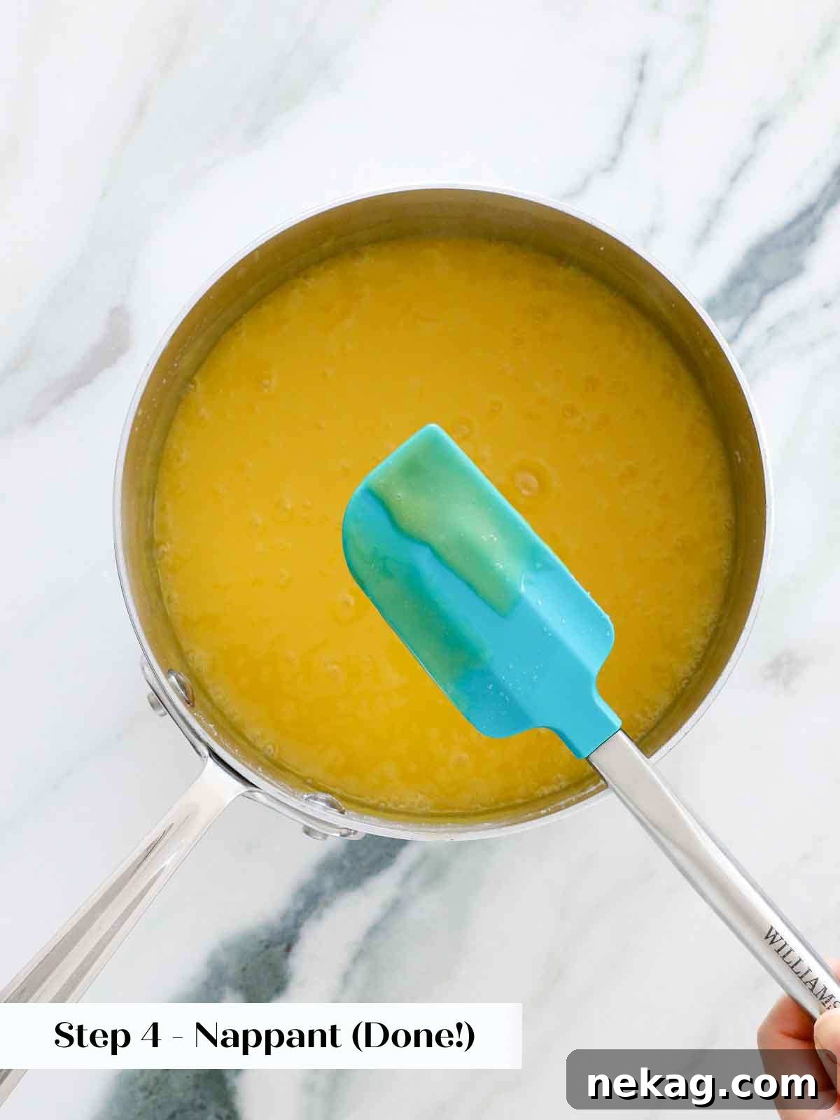 A finger drawn through lemon curd on the back of a spoon, showing the 'nappant' stage where the line holds perfectly.