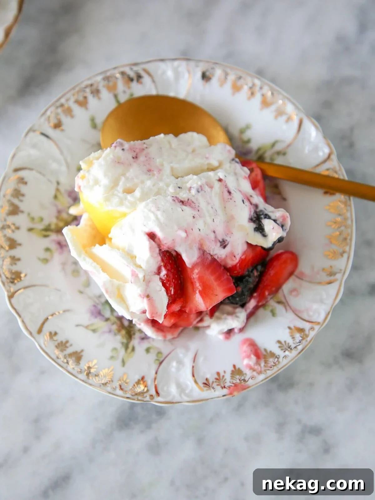 A serving of lemon berry pavlova cake on a white plate.