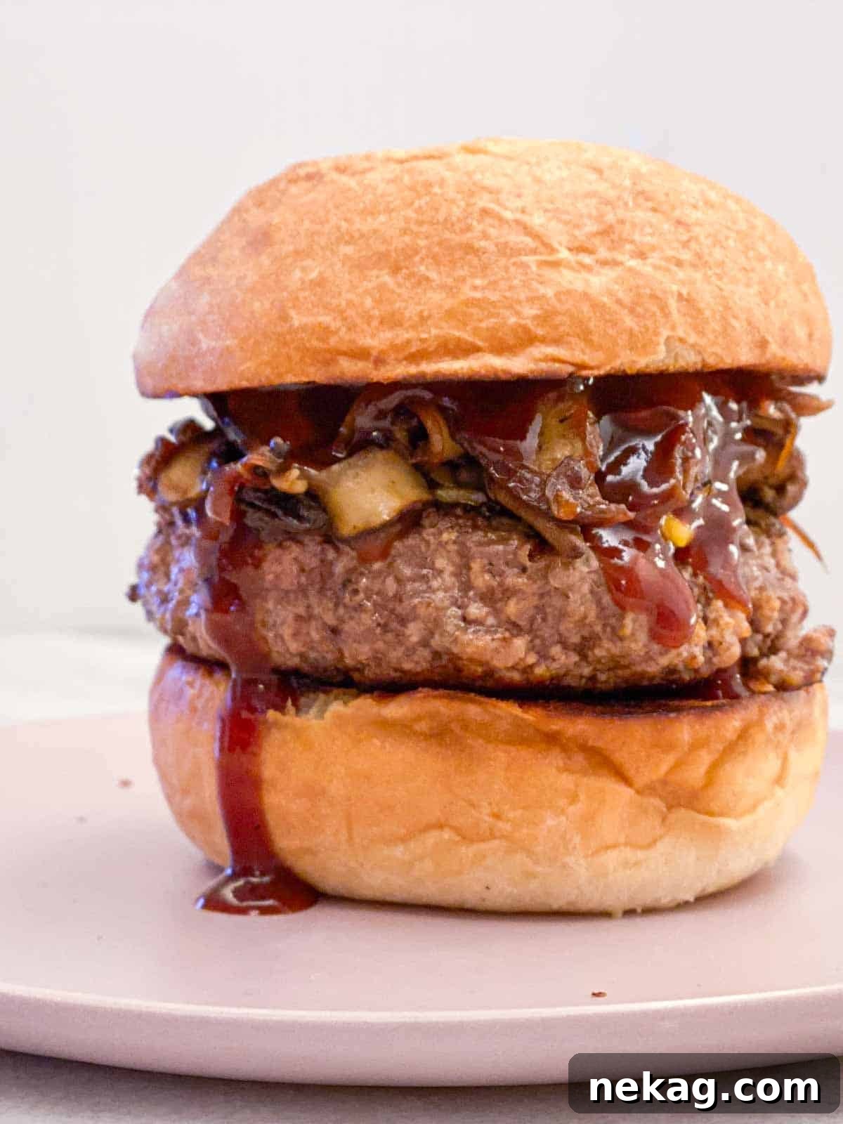 Pillowy Soft Brioche Buns 8 A mouthwatering tall burger served on a fluffy brioche bun, placed on a chic pink plate.