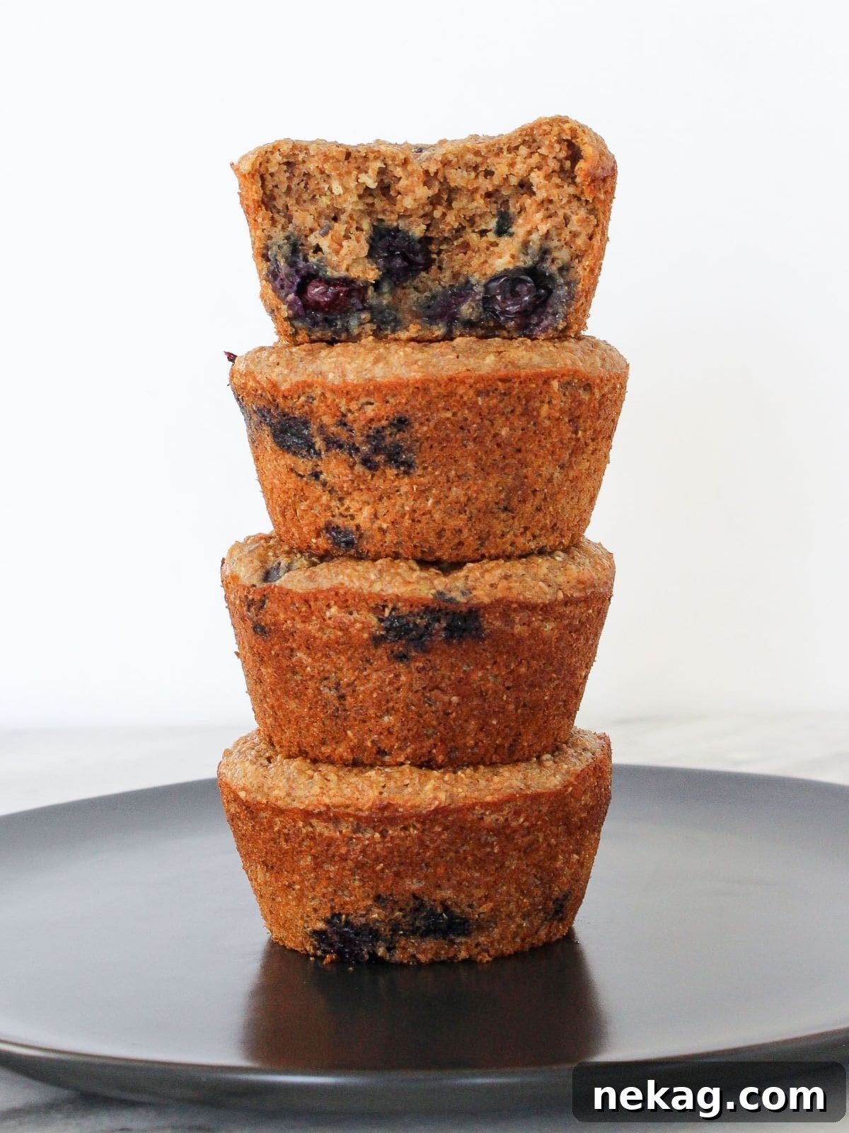 Protein-Powered Banana Muffins 2 Freshly baked banana protein muffins stacked neatly on a grey plate, ready for a healthy breakfast or convenient meal prep.