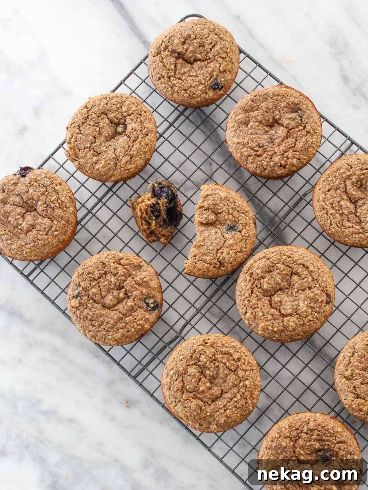 Protein-Powered Banana Muffins 12 Freshly baked banana protein muffins cooling gracefully on a wire rack, set against a pristine white marble background, perfect for healthy meal prep or anytime snacking.