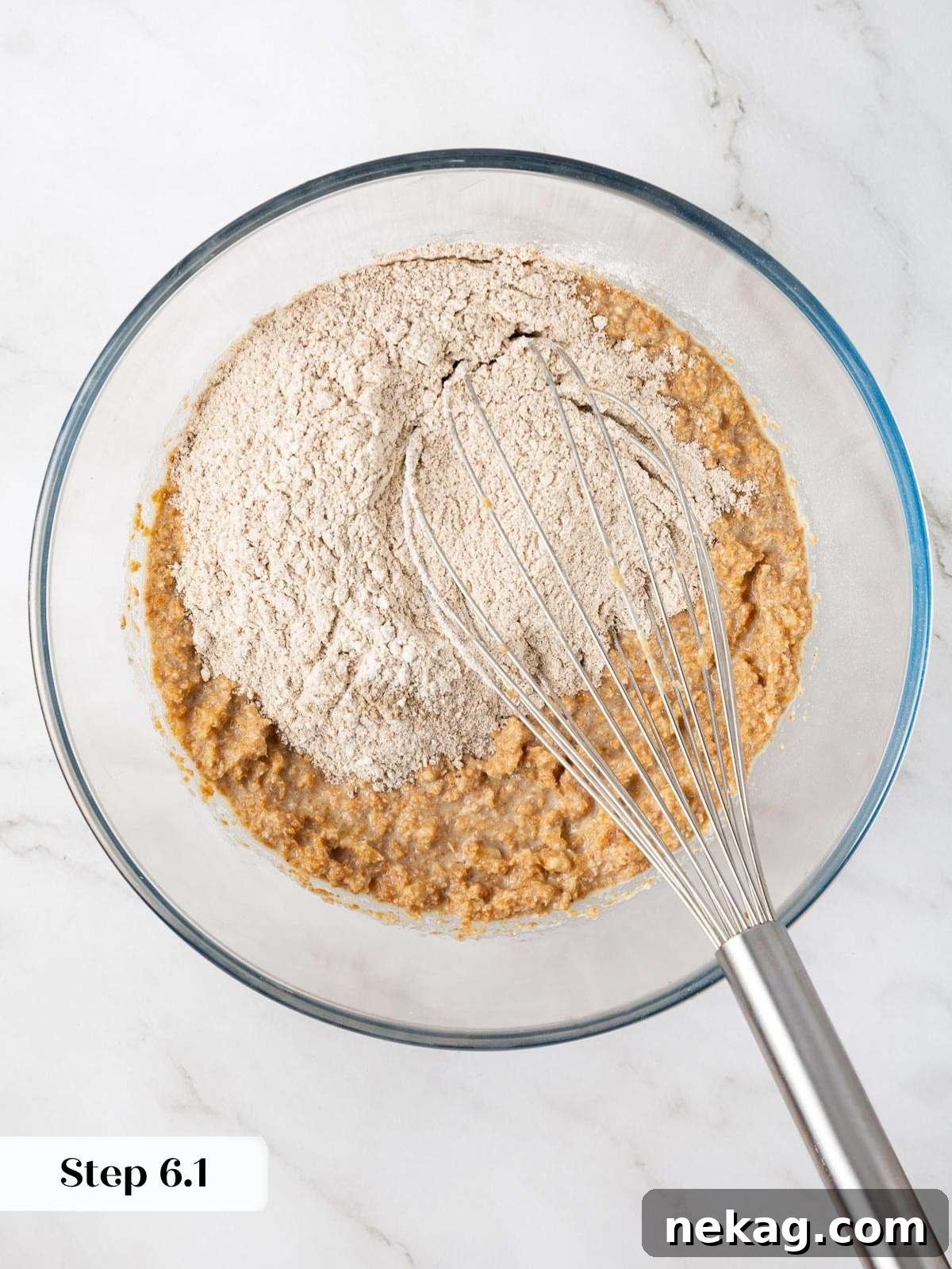 Protein-Powered Banana Muffins 8 The flour mixture being carefully added to a bowl of wet ingredients, illustrating the crucial gentle folding technique necessary for light and tender banana protein muffin batter.