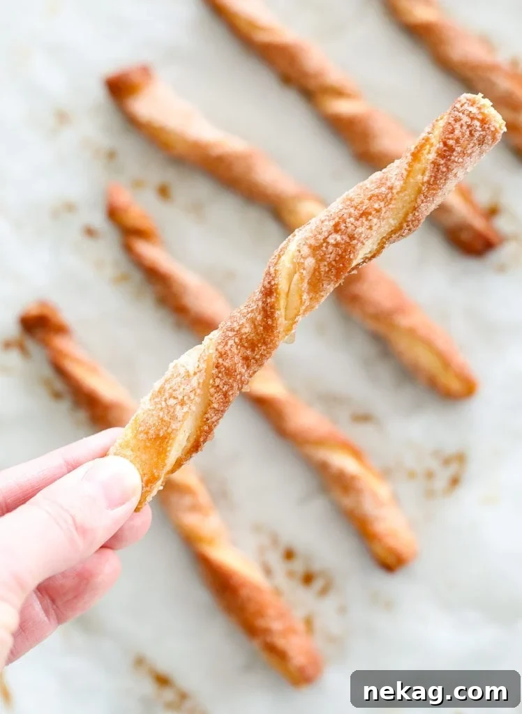 Close-up of unbaked Cinnamon Sugar Twists being twisted on a floured surface