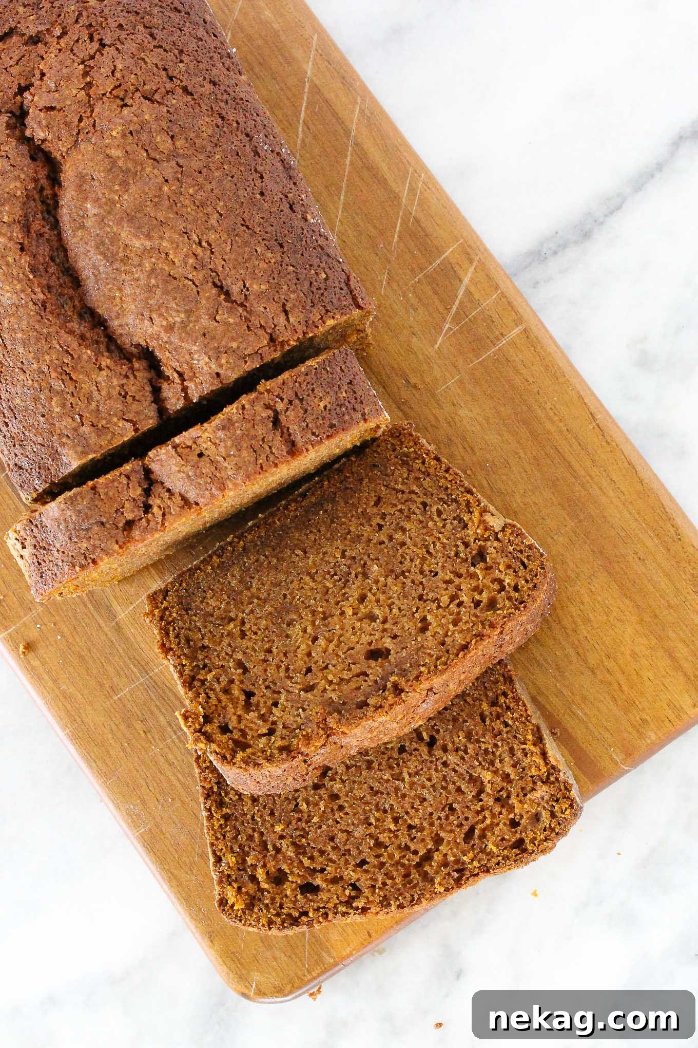 Spiced Pumpkin Delight 2 Sliced pumpkin bread on a wooden board, showcasing its moist texture.