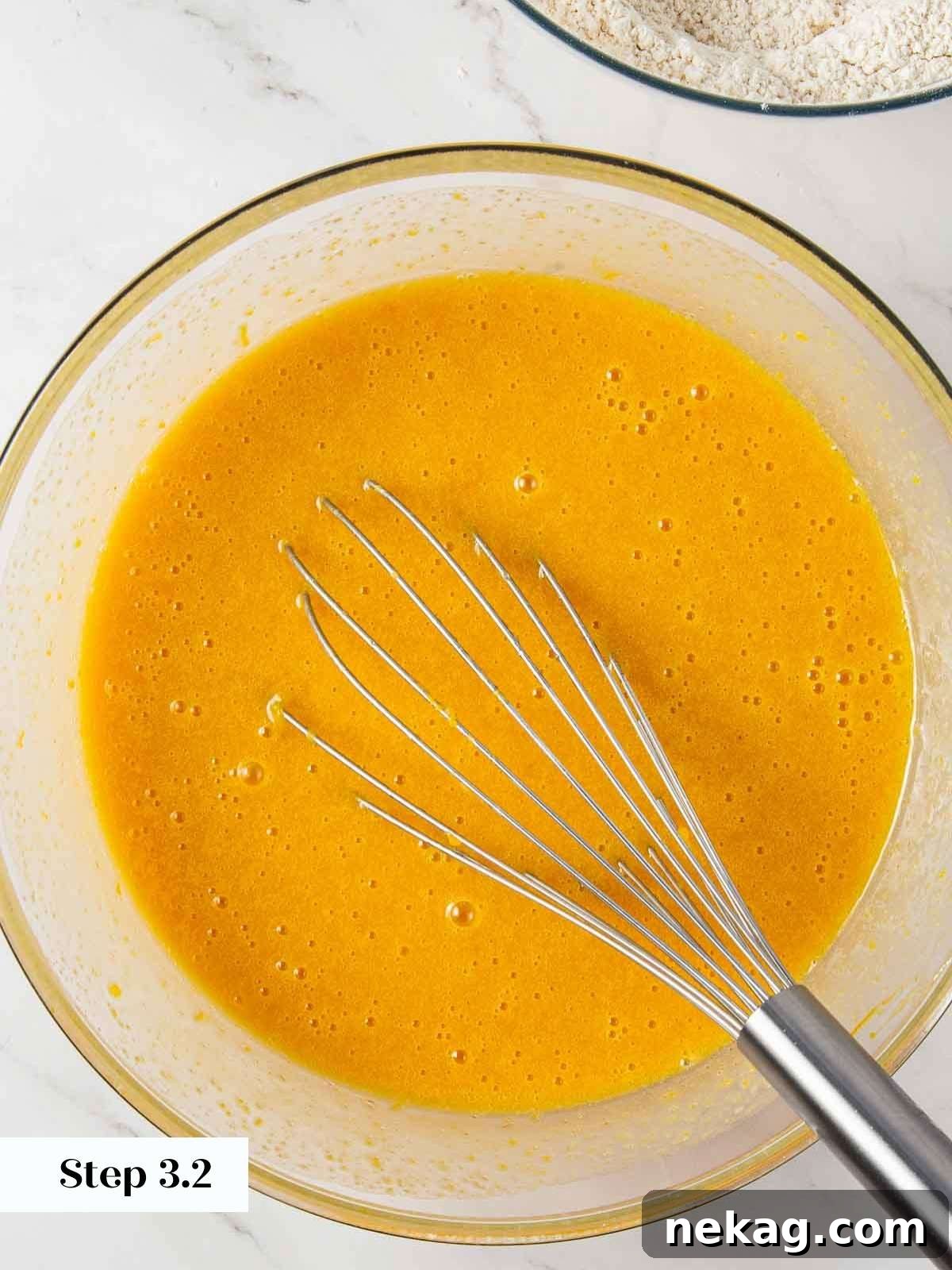 Spiced Pumpkin Delight 8 Wet ingredients for pumpkin bread fully combined in a mixing bowl, showing the smooth, emulsified mixture.