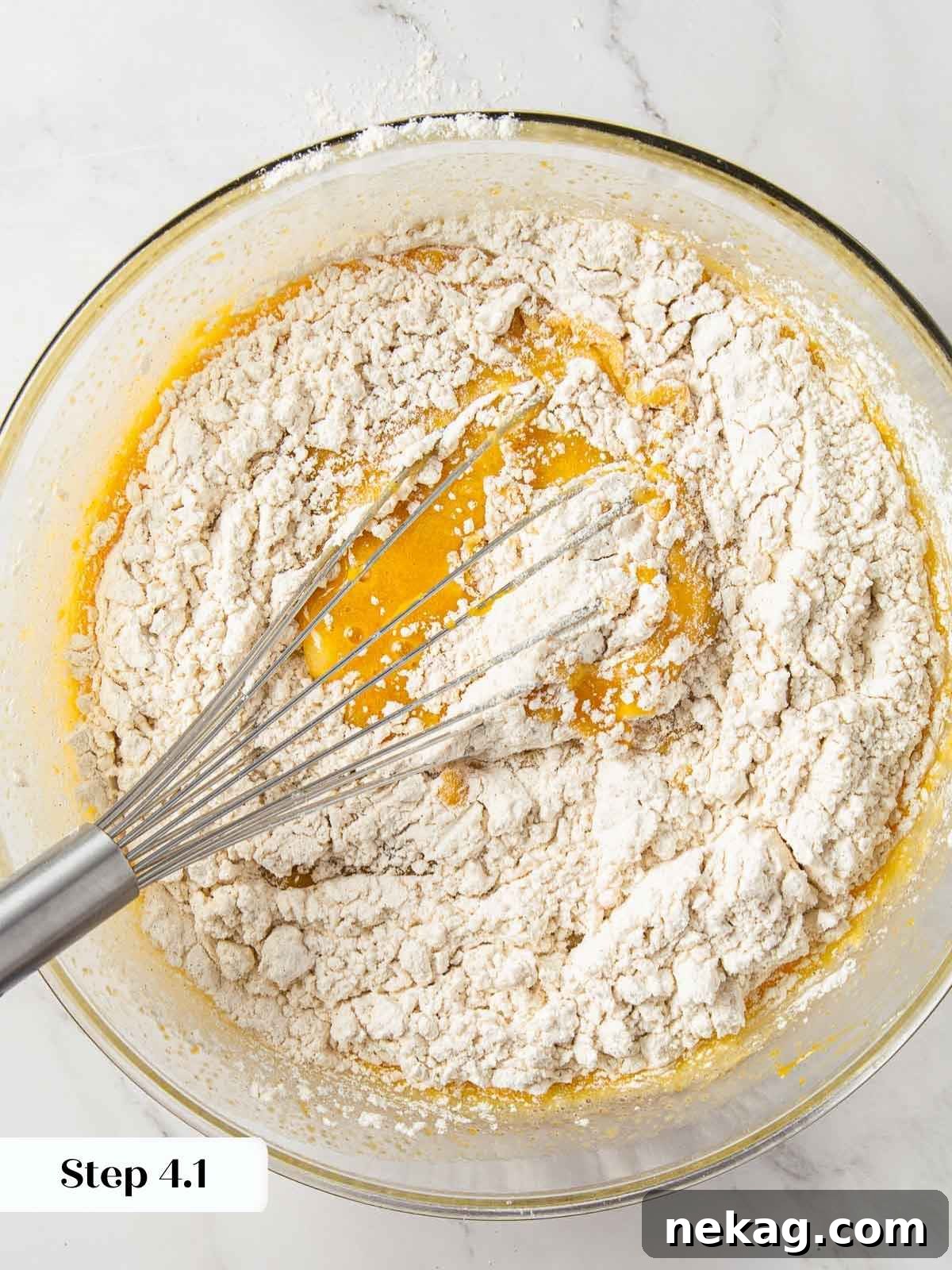 Spiced Pumpkin Delight 9 Wet and dry ingredients for pumpkin bread being mixed together, showing partial incorporation.