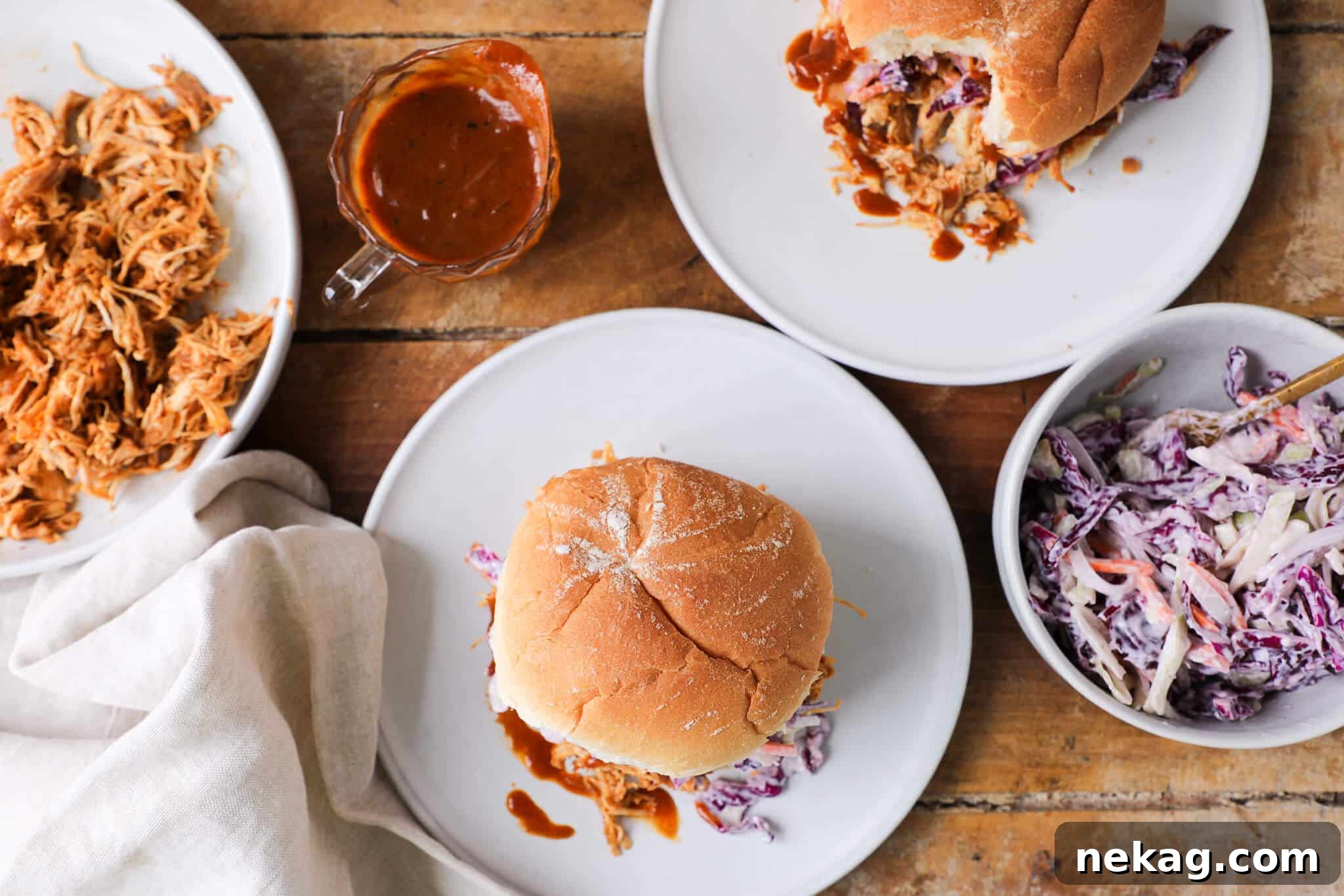 Gourmet Slow Cooker BBQ Pulled Chicken Sandwich with Fresh Coleslaw on a wooden table.