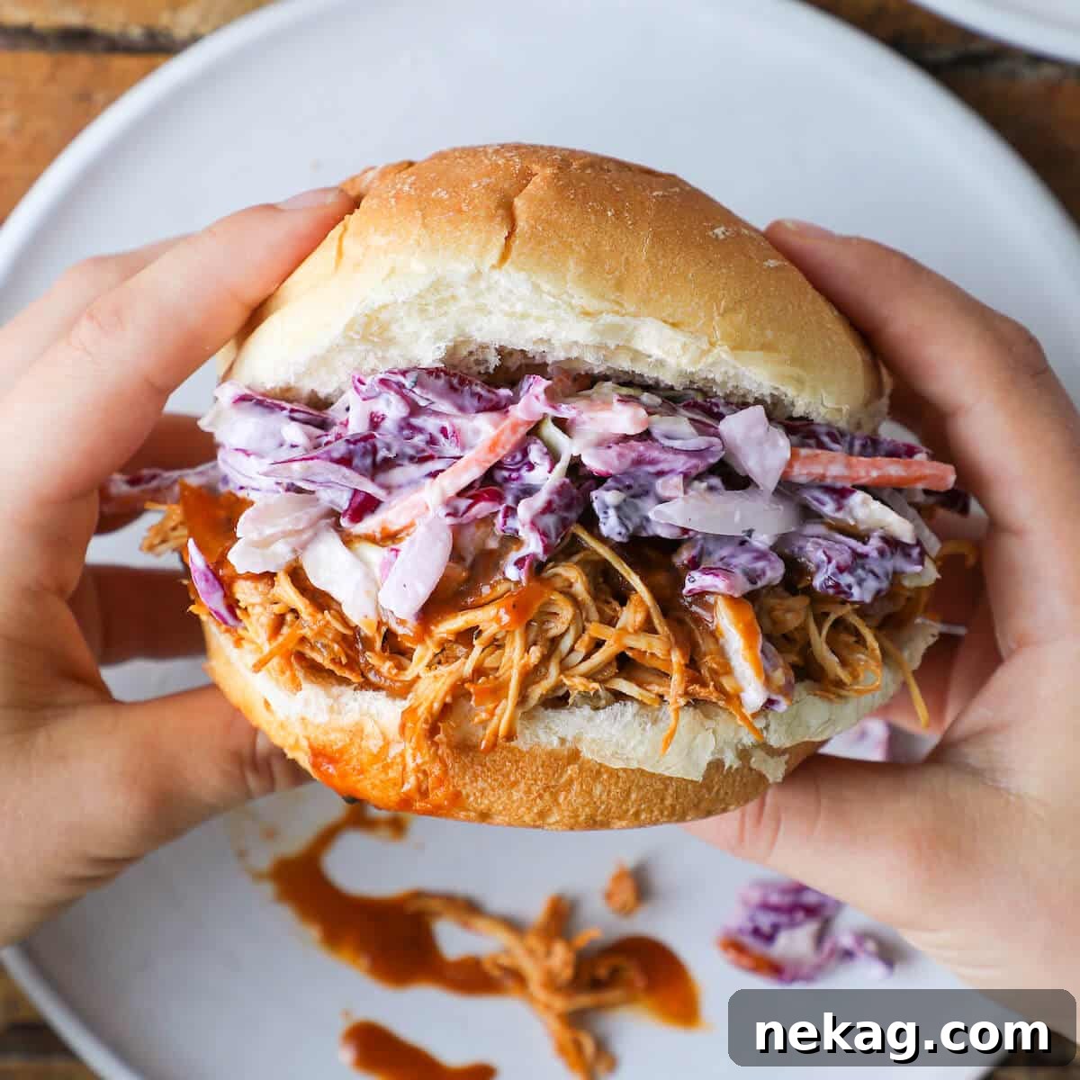 Perfectly Cooked Barbecue Pulled Chicken Sandwich Ready to Eat, held by hand.