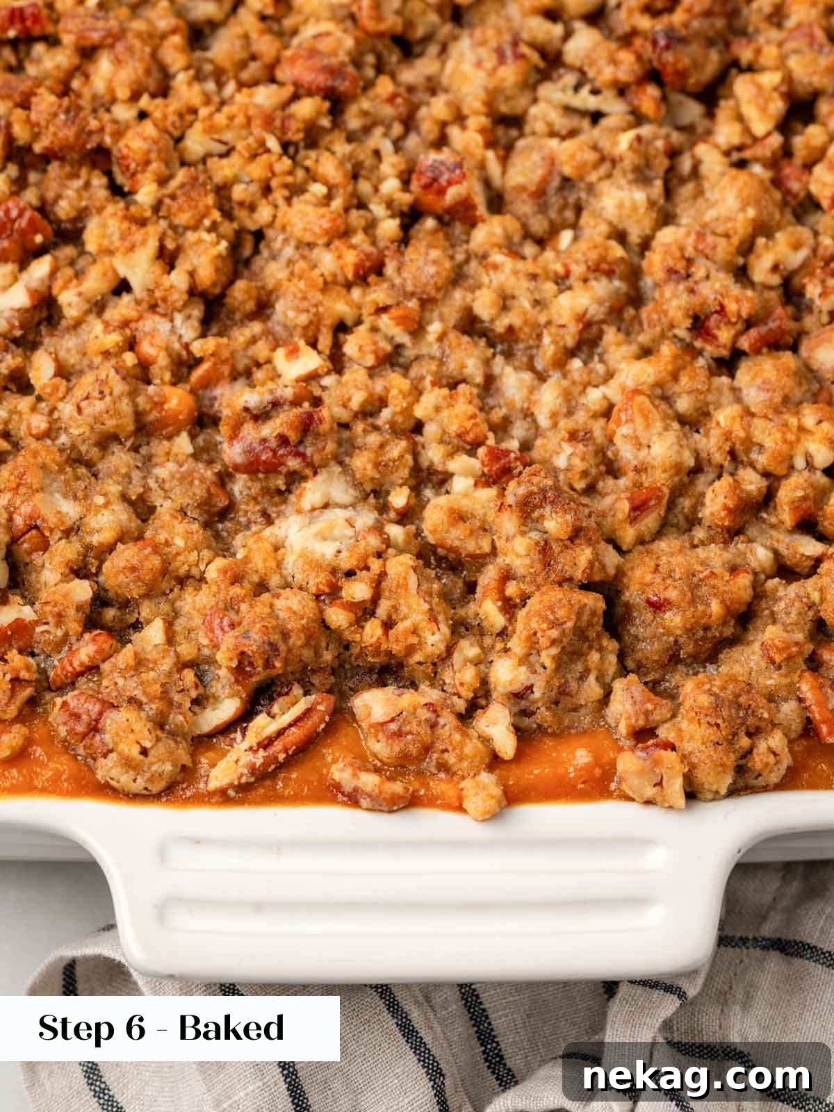 The fully baked sweet potato casserole, golden brown with a rich pecan crumble topping, bubbling around the edges.