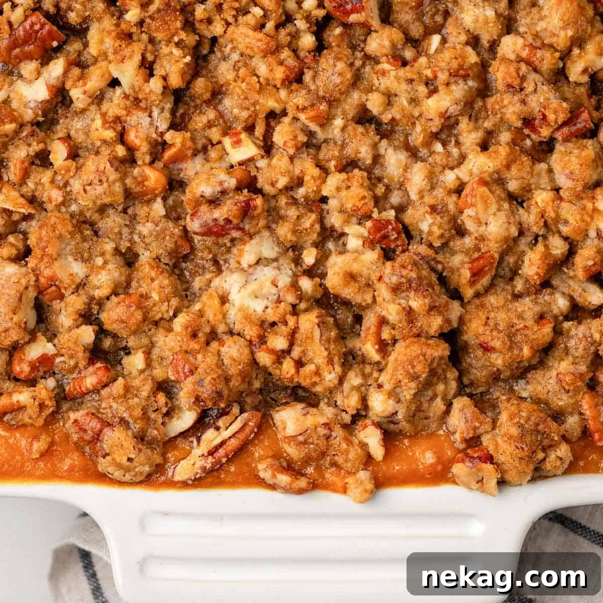 Freshly baked sweet potato casserole, golden brown and bubbling, presented in a clean white serving dish.