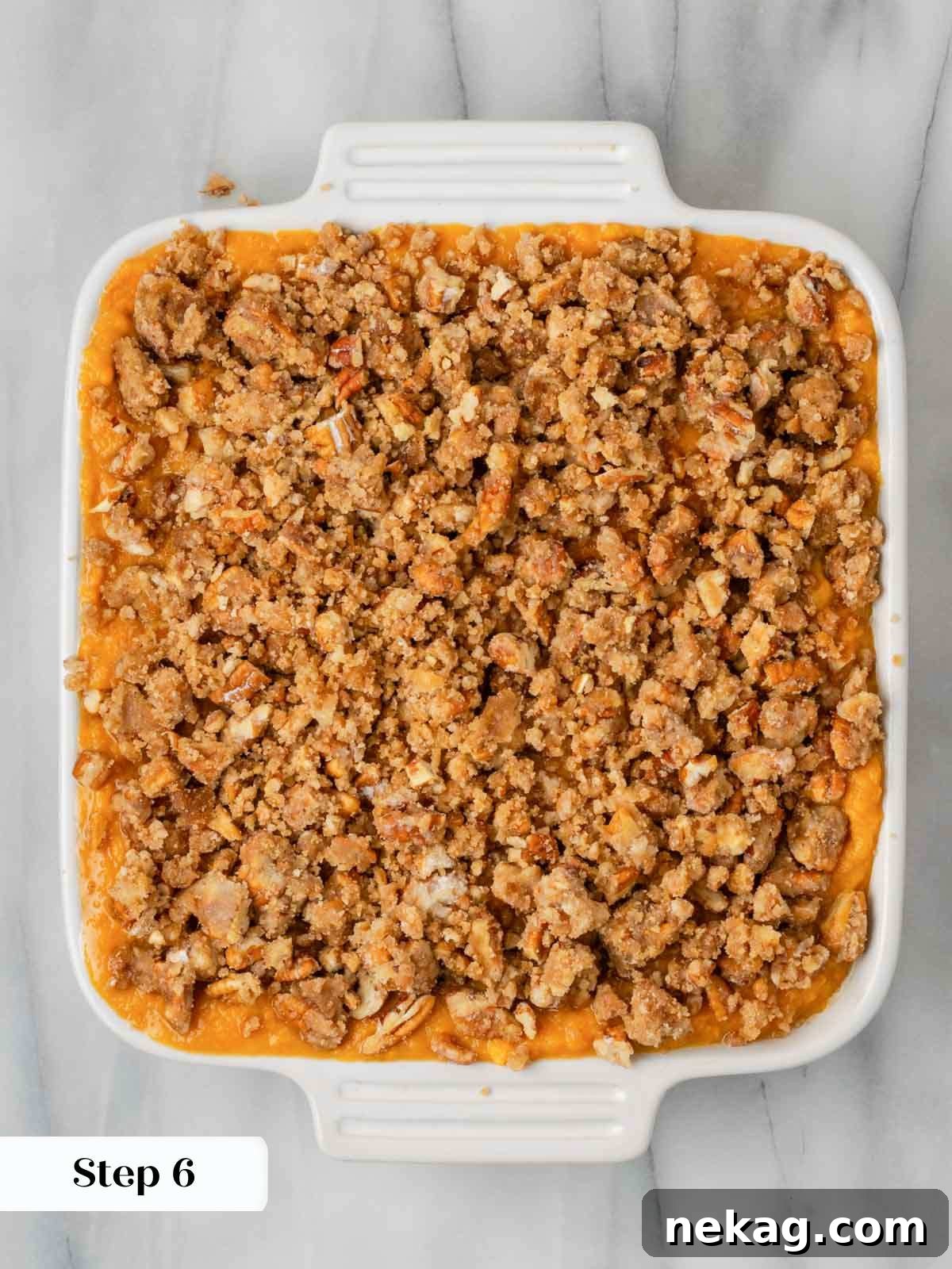 Unbaked sweet potato casserole base, smooth and creamy, in a white baking dish before the topping is added.