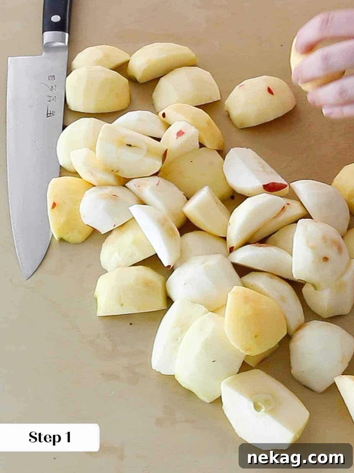 Sliced apples on a cutting board next to a Japanese knife, ready for preparation.