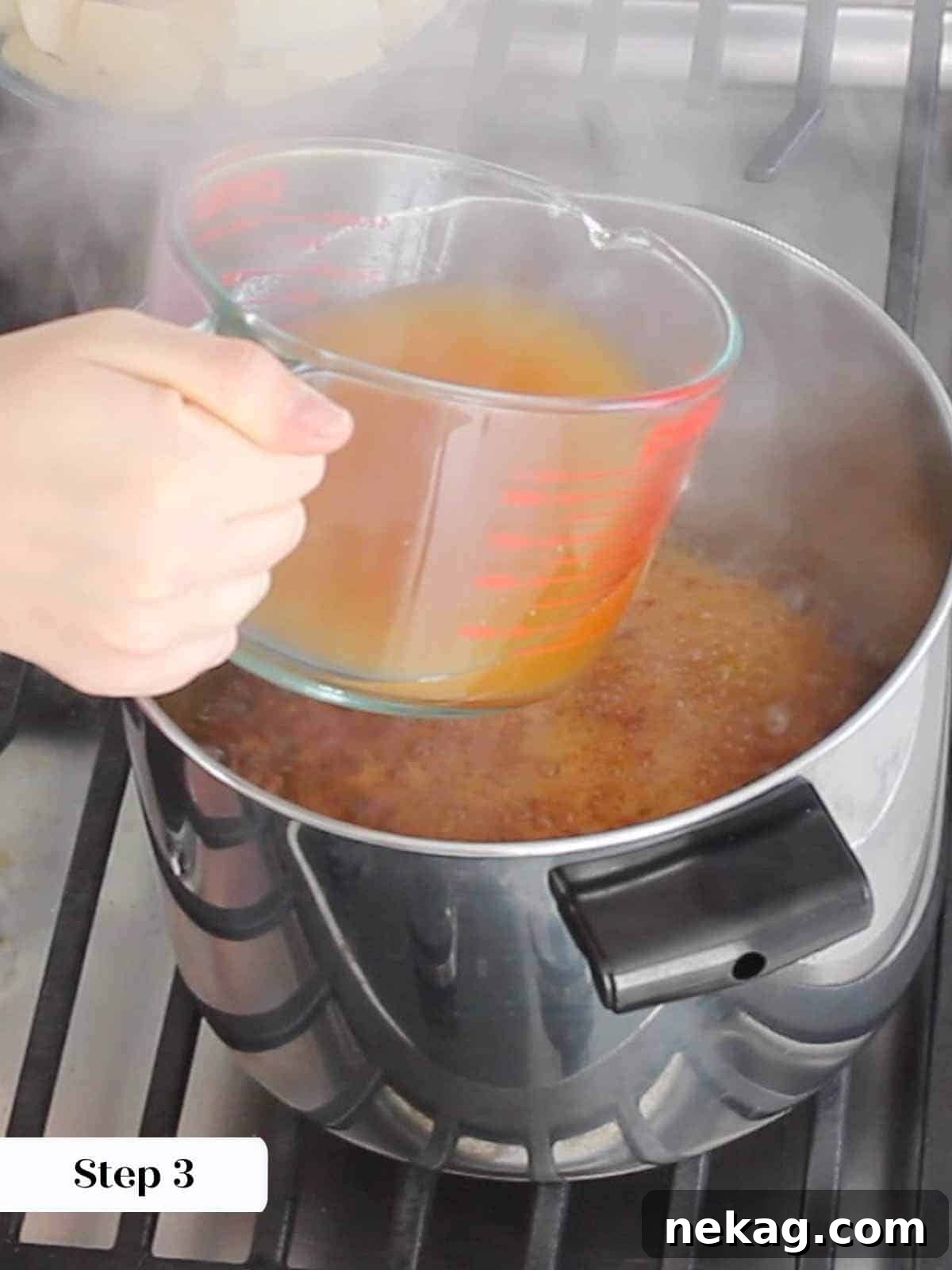 Apple cider being added to the dark amber caramel in a pot, creating steam.