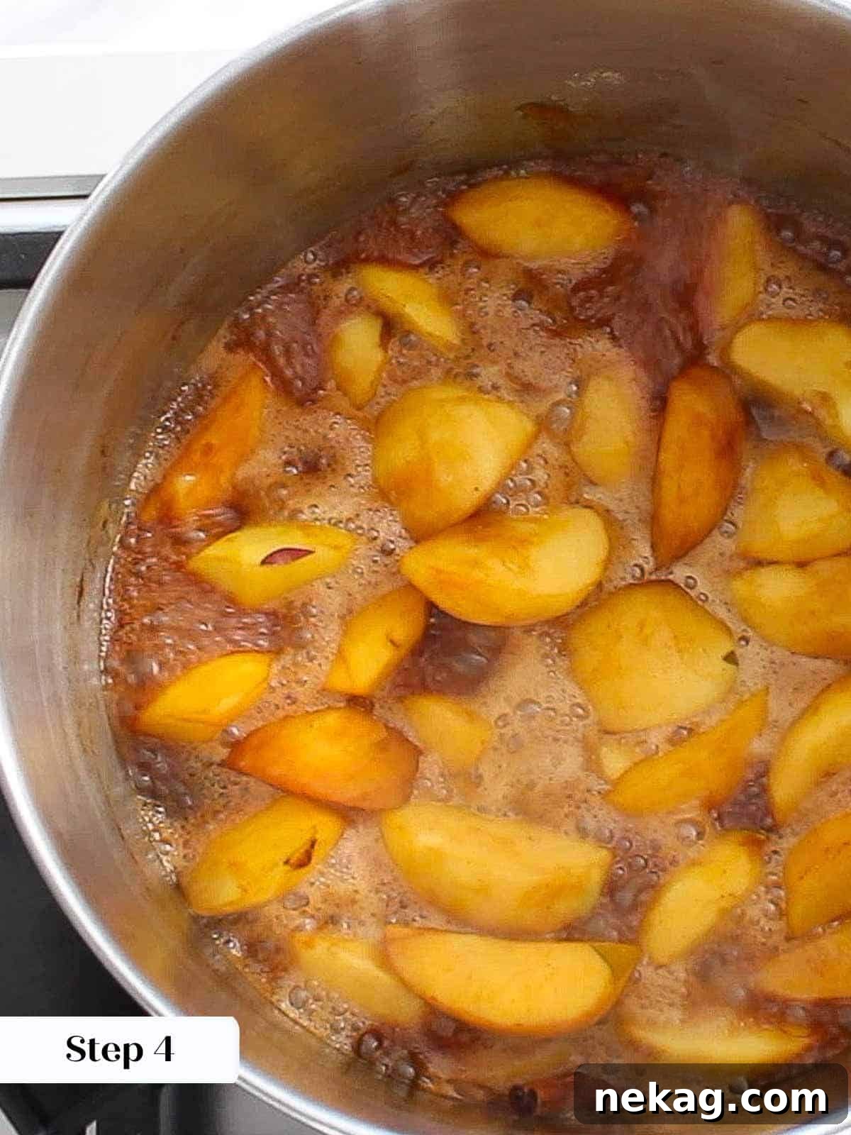 Apples and spices simmering in the pot, cooking down into apple butter.